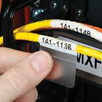 Etiquetas envolventes colocadas cuidadosamente alrededor de unos cables.