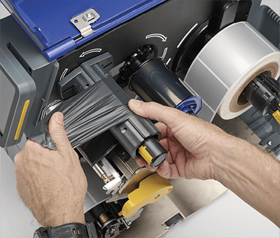 Un empleado carga con agilidad una impresora i7500 con una cinta de impresión nueva.