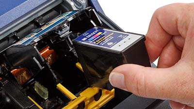 Una persona cargando un cartucho de tinta.