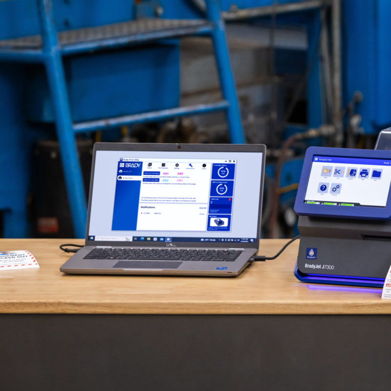 Un portátil conectado a una J7300 en el que se ve una pantalla de Brady Workstation.
