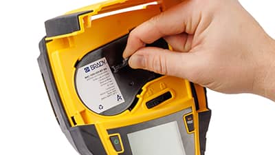 Carga de un rollo de material para etiquetas en una impresora M710.